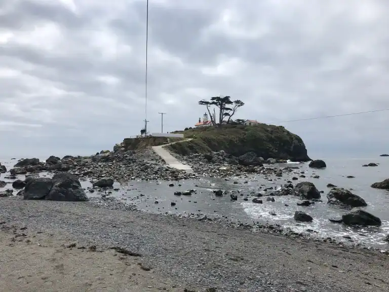 Rocky tidal causeway leading to Battery Point Lighthouse in Crescent City California at low tide