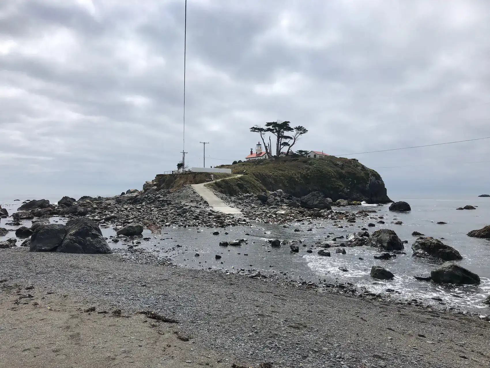 Rocky tidal causeway leading to Battery Point Lighthouse in Crescent City California at low tide
