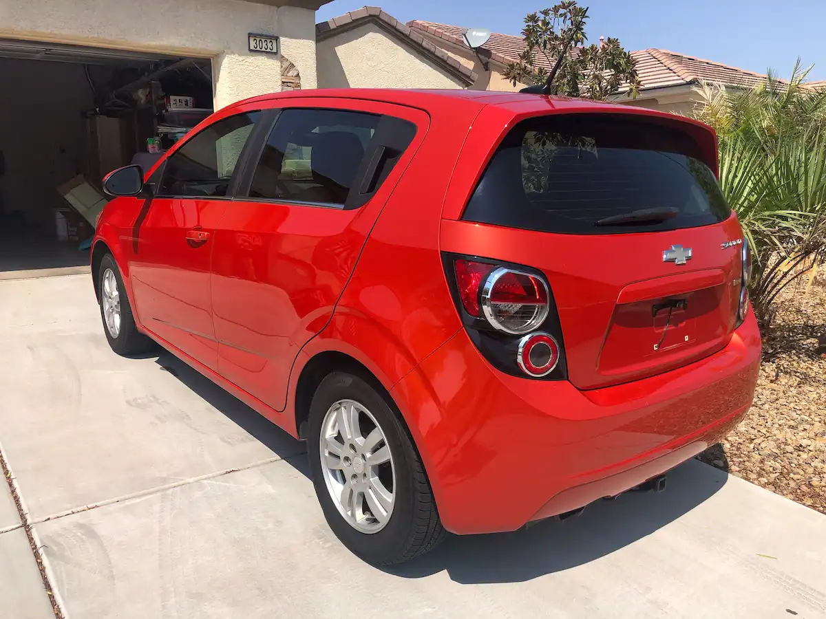 Bright orange Chevy Sonic hatchback, the tiny car we packed our life into to start full-time travel.