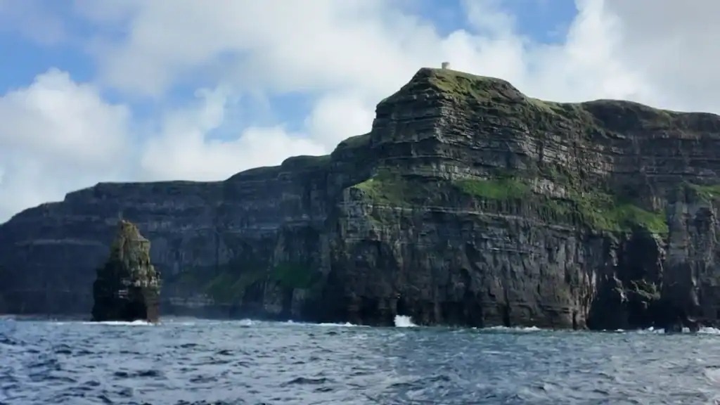 Cliffs of Moher rising above rough seas in Ireland