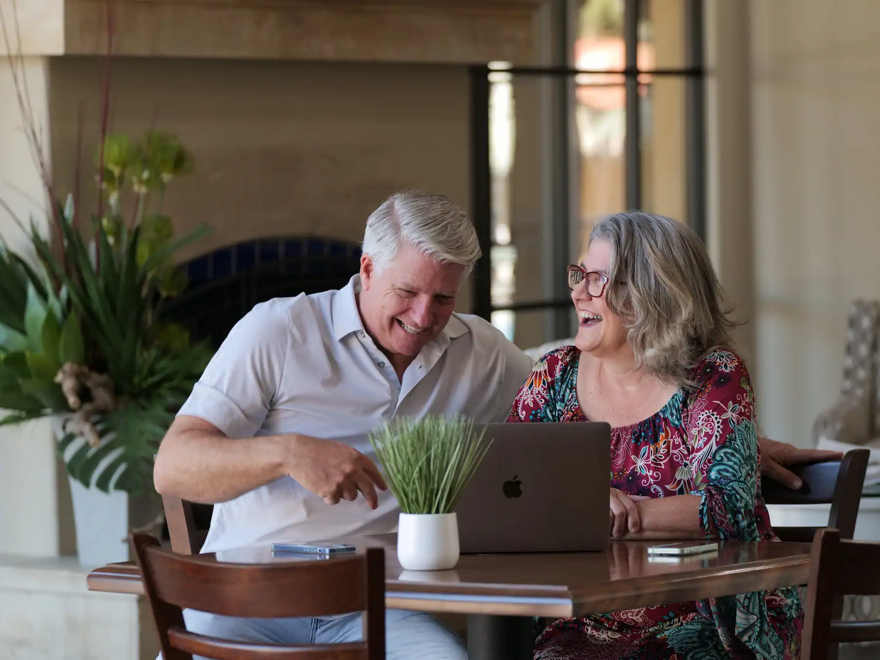 Matt and Linda Lutz laughing together at a table, a couple married 34 years who run their marriage on 100/100 instead of keeping score