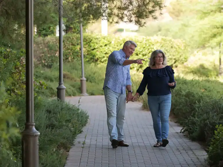 Matt and Linda walking together outdoors, talking and laughing, a couple who figured out how to talk to your spouse for 34 years